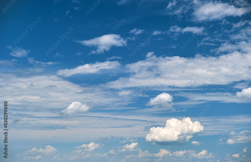 Bright landscape of white puffy cumulus clouds on blue clear sky Bright landscape of white puffy cumulus clouds on blue clear sky