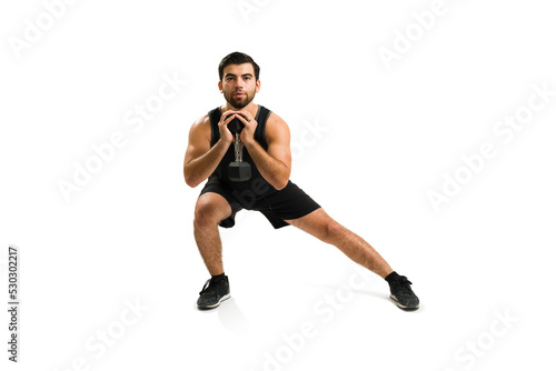Determined young man doing cross training with weights
