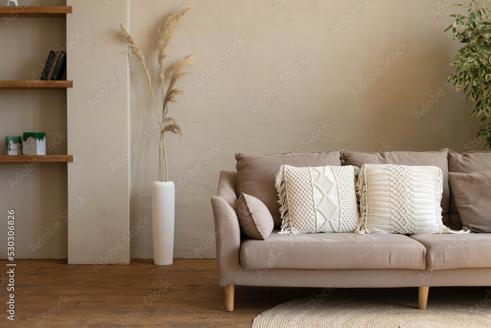 Sofa with macrame cushions on a woven round rug in a modern living room in  beige tones. Cozy interior of a country house. foto de Stock | Adobe Stock