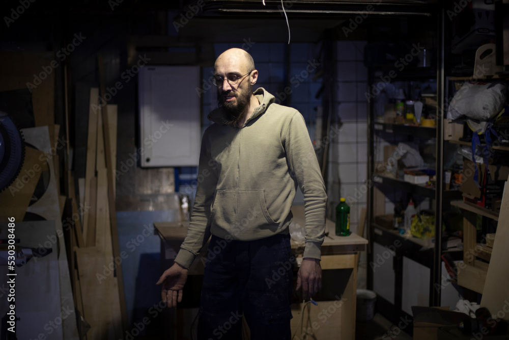 Guy in work garage. Man is dissatisfied with work. Guy in work garage. Man is dissatisfied with work.