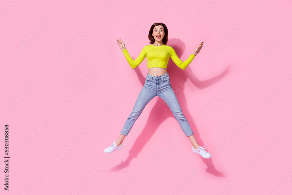 Full size portrait of overjoyed cheerful person jumping have fun good mood isolated on pink color background Full size portrait of overjoyed cheerful person jumping have fun good mood isolated on pink color background