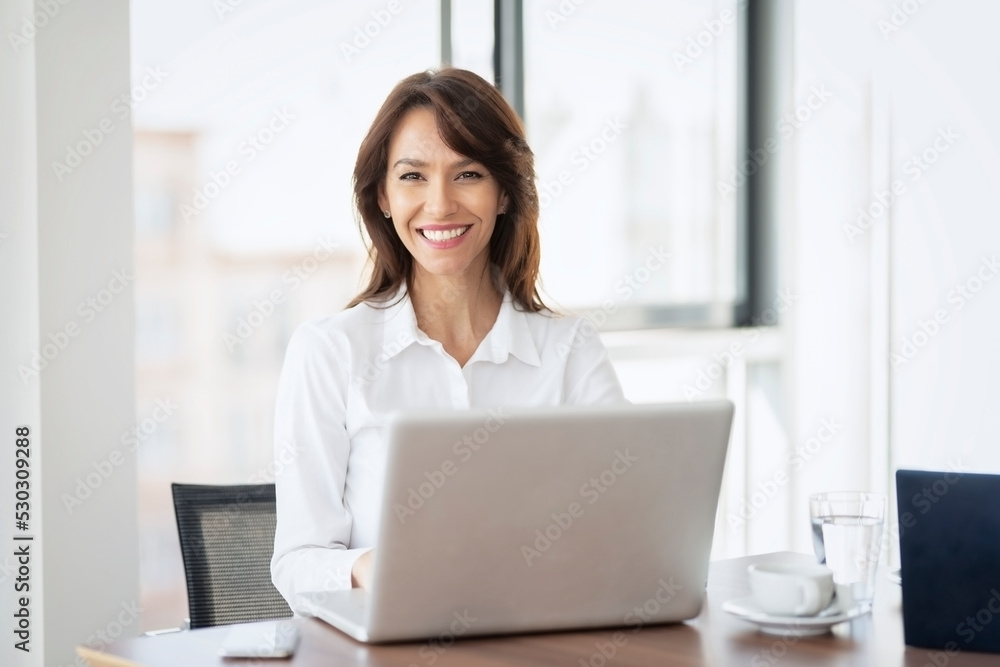 Shot of an attractive businesswoman working on a laptop in an office Shot of an attractive businesswoman working on a laptop in an office