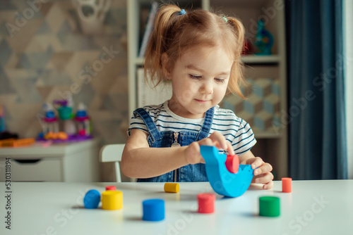 The baby is playing at the table. Early child development.