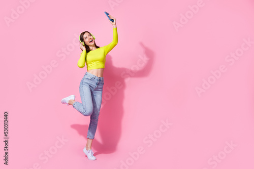 Full size photo of happy joyful lady dancer use gadget make blog video talk record dance fun empty space isolated on pink color background