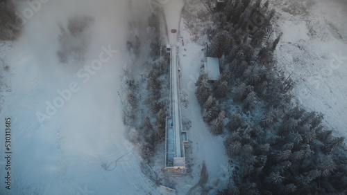 фотографія Sunrise breaking through the thick white mist at the top of Vuokatti Hill, a ski resort in Vuokatti, Finland