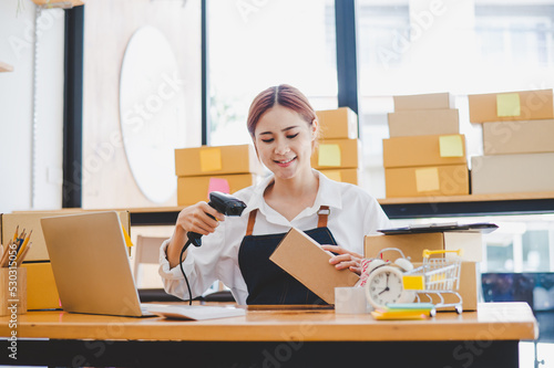 Small business owners online are scanning barcode-labelled parcel boxes with a barcode scanner to verify their product orders. of online retailers - online shopping