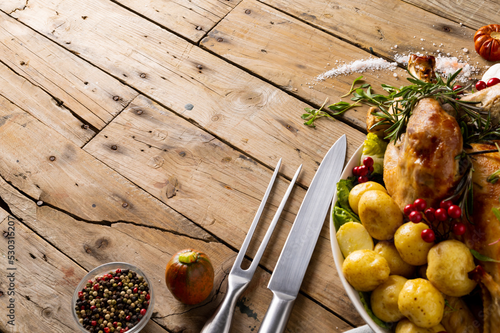 Obraz premium Overhead view of thanksgiving table with roast turkey, potatoes and copy space on wood