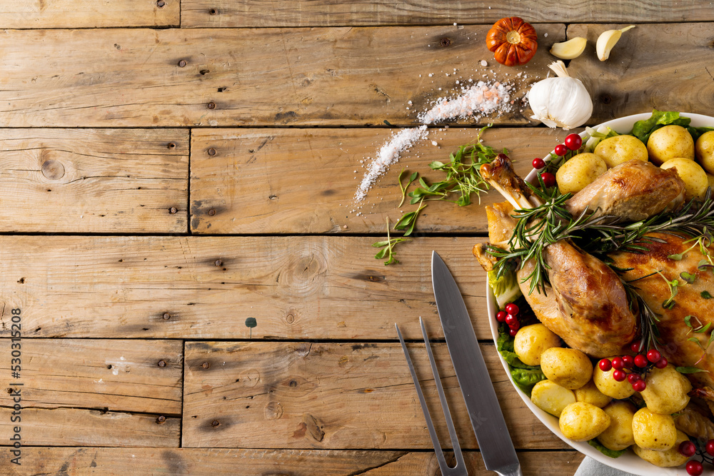 Fototapeta premium Overhead view of thanksgiving table with roast turkey, potatoes and copy space on wood