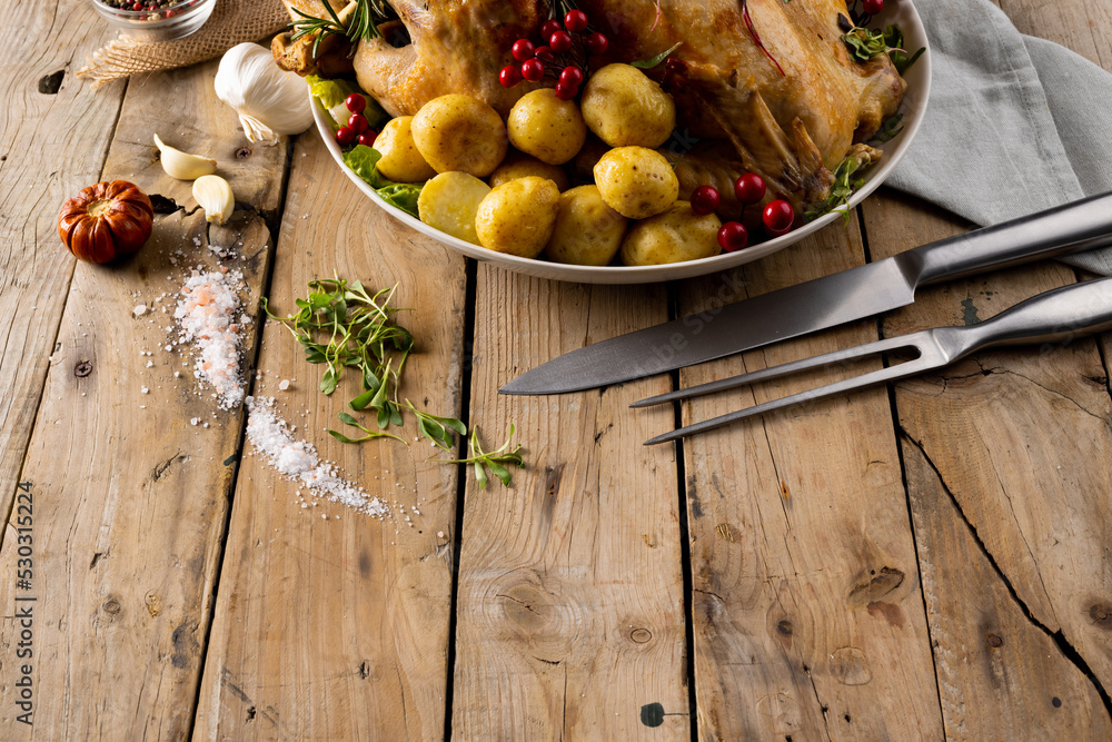 Fototapeta premium Overhead view of thanksgiving table roast turkey, potatoes, autumn decoration and copy space on wood