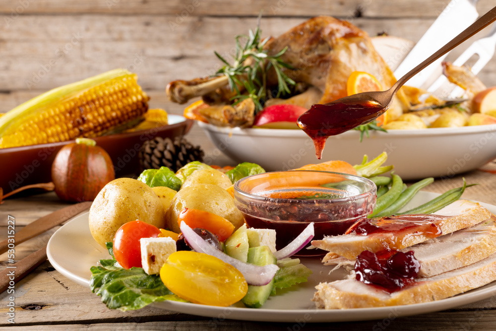 Fototapeta premium Close up of plate of thanksgiving roast turkey with vegetables on wooden background