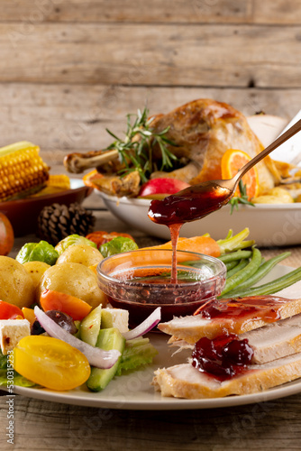 Close up of plate of thanksgiving roast turkey with vegetables on wooden background