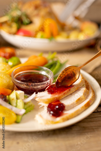 Close up of plate of thanksgiving roast turkey with vegetables on wooden background