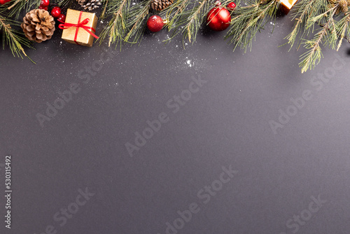 Image of christmas decoration with baubles and copy space on black background