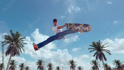 Fotografie Skateboarder doing a trick in a skate park