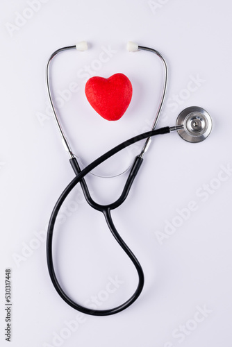 Vertical image of red heart and stethoscope on white surface