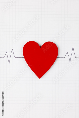 Vertical image of red heart and heart rate on white surface
