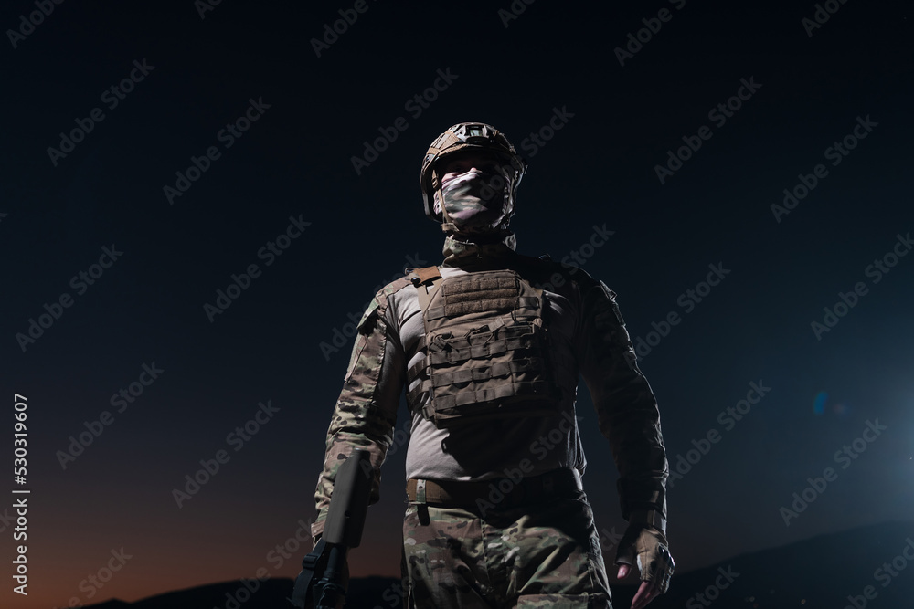 Army soldier in Combat Uniforms with an assault rifle, plate carrier and combat helmet going on a dangerous mission on a rainy night. Army soldier in Combat Uniforms with an assault rifle, plate carrier and combat helmet going on a dangerous mission on a rainy night.
