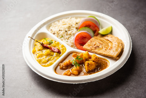 Indian mini meal parcel platter or combo thali with Gobi Masala, roti, dal tarka, jeera rice, salad
