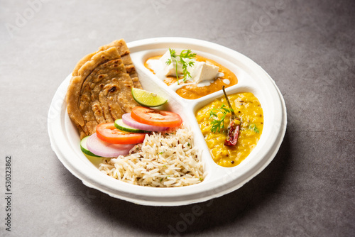 North Indian mini meal, parcel platter or combo thali with paneer butter masala, roti, dal and rice photo