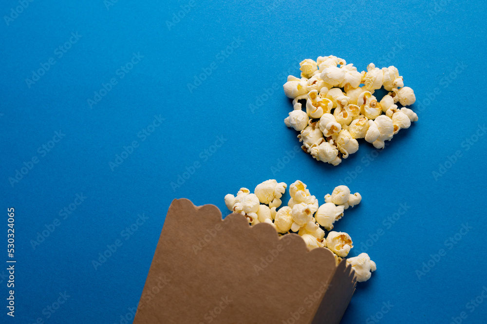 Image of pop corn scattered on blue surface Image of pop corn scattered on blue surface