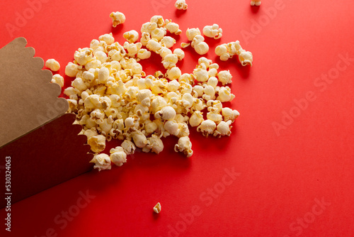Image of pop corn lying on red surface