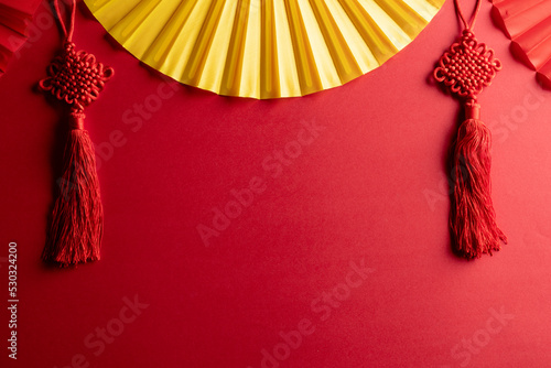 Composition of traditional chinese fans and decorations on red background