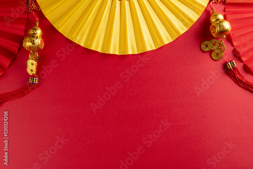 Composition of traditional chinese fans and decorations on red background