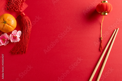 Composition of traditional chinese decorations and chopsticks on red background