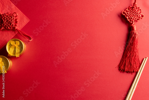 Composition of traditional chinese decorations and chopsticks on red background