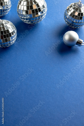 Composition of close up of new years baubles on blue background