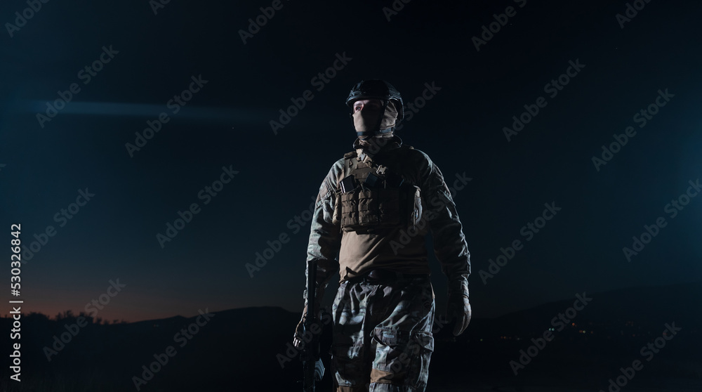 Army soldier in Combat Uniforms with an assault rifle, plate carrier and combat helmet going on a dangerous mission on a rainy night. Army soldier in Combat Uniforms with an assault rifle, plate carrier and combat helmet going on a dangerous mission on a rainy night.