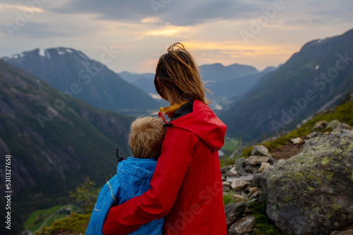Family with children and dog, hiking in Litlefjellet on sunset, enjoying amazing view from the top of hiking trail © Tomsickova