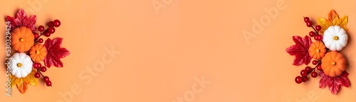 Autumn bouquet of acorns, berries, maple leaves, pumpkins isolated on orange background Flat lay Top view Floral border Holiday card Hello September, October, November concept