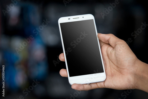 Close up, man hands holding smart phone with blank copy space screen for your text message on dark and blurry background