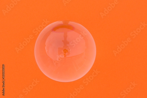 glass spherre on orange background photo