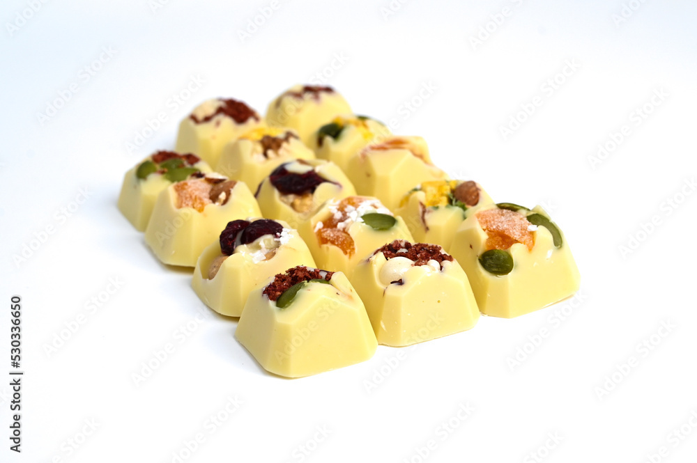 Set of handmade bonbons on white background. Exclusive handcrafted chocolate candies with fruit and nuts filling Set of handmade bonbons on white background. Exclusive handcrafted chocolate candies with fruit and nuts filling