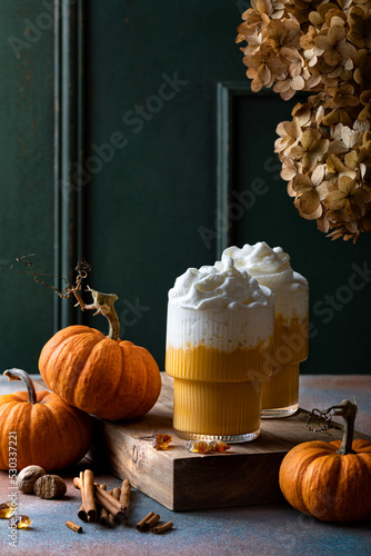 Spicy pumpkin latte with whipped cream. Autumn or winter hot coffee drink with cinnamon, nutmeg photo