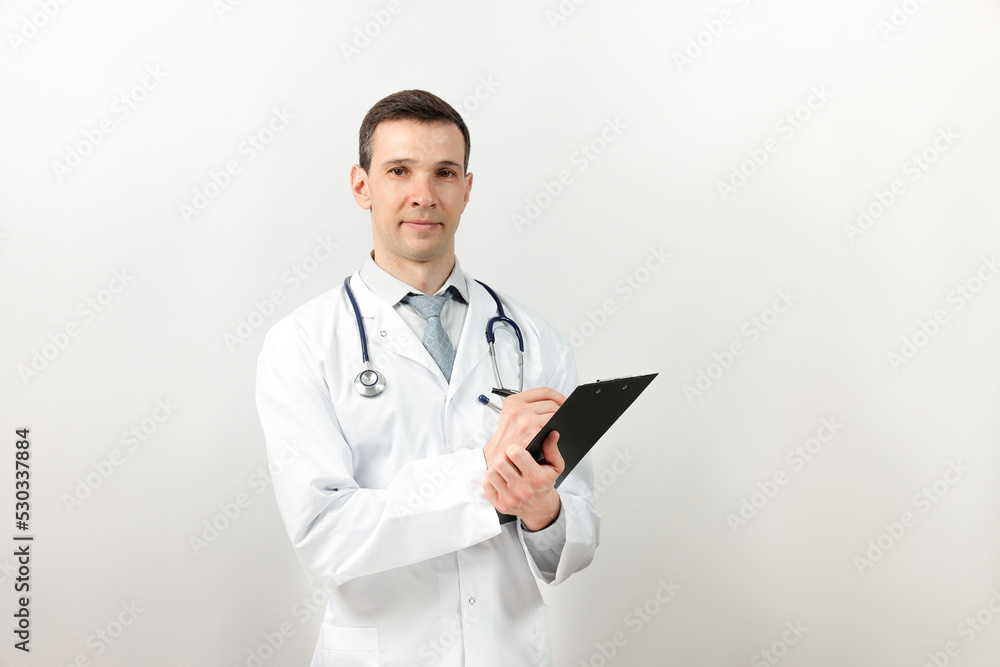 Medical services. Young doctor with stethoscope and clipboard looking at camera. Copy space. Medical services. Young doctor with stethoscope and clipboard looking at camera. Copy space.