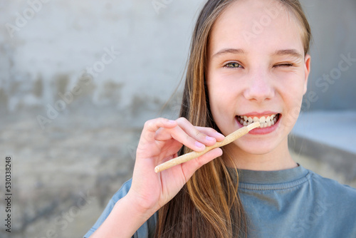A girl brushes her teeth siwak stick. Miswak sticks. photo