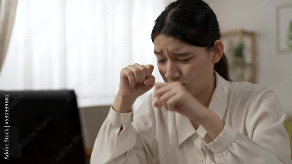 closeup of an overworked Asian woman manager working from home is suffering blurry vision and rubbing her eyes while using computer in the living room closeup of an overworked Asian woman manager working from home is suffering blurry vision and rubbing her eyes while using computer in the living room