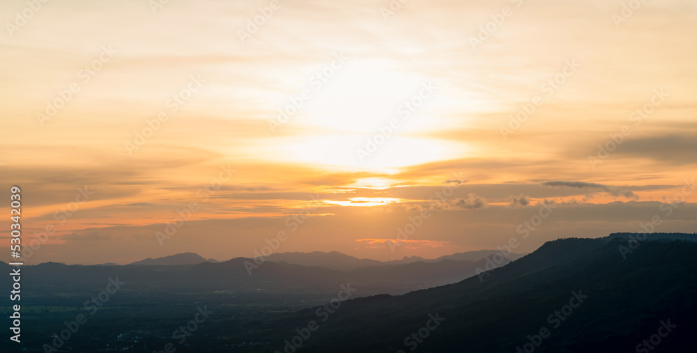 Landscape of mountain range with sunset sky. Mountain at dusk. Orange sky and clouds at sunset. Mountain valley. Mountain layer at dusk. Beauty in nature. Tranquility scene. Beautiful sunset sky.