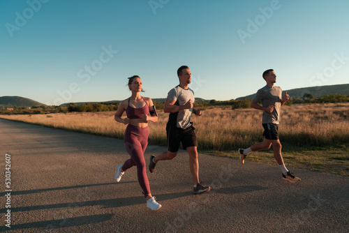 Three runners sprinting outdoors - Sportive people training in a urban area, healthy lifestyle and sport concepts