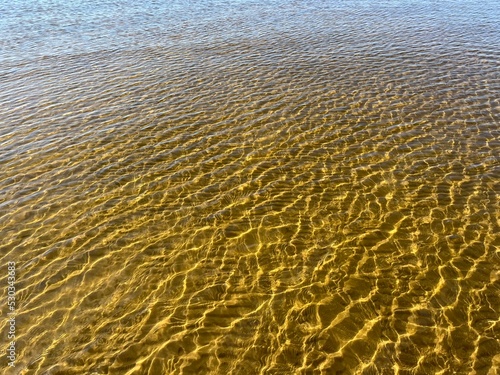 Transparent sea water ripples  sandy bottom  natural background