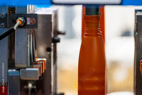 The orange bottle container manufacturing process by blow mold machine.