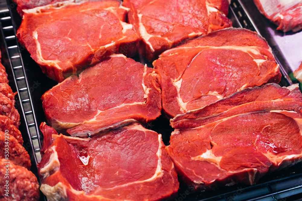 Close up photo of some red fresh beef steak from a meat shop or restaurant stand.