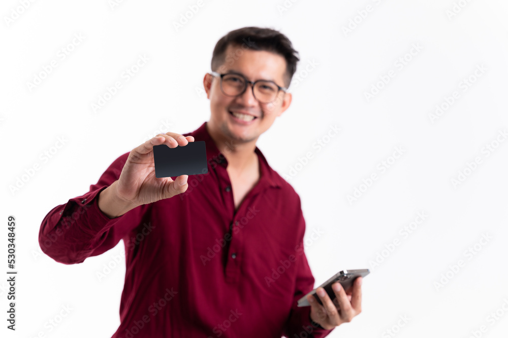 Asian man showing credit card for mobile payment concept in studio white isolated background. Handsome smiling young asian man. Online buying and selling concept and pay by credit card. Asian man showing credit card for mobile payment concept in studio white isolated background. Handsome smiling young asian man. Online buying and selling concept and pay by credit card.