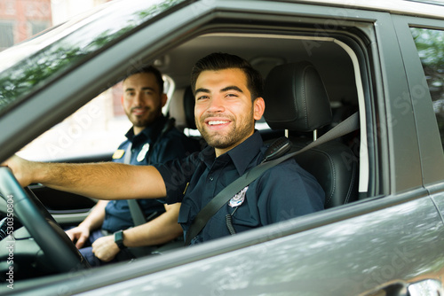 фотографія Cheerful police officer on duty driving the patrol car