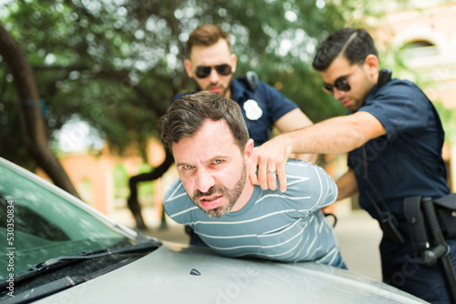 Fotografia, Obraz Portrait of a criminal looking upset after his police arrest