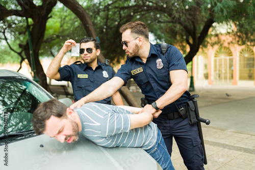 Good police officers arresting a drug dealer in the street photo