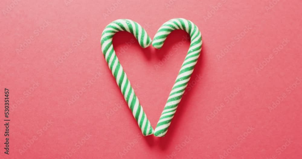 Video of two green christmas canes over bright red background Video of two green christmas canes over bright red background